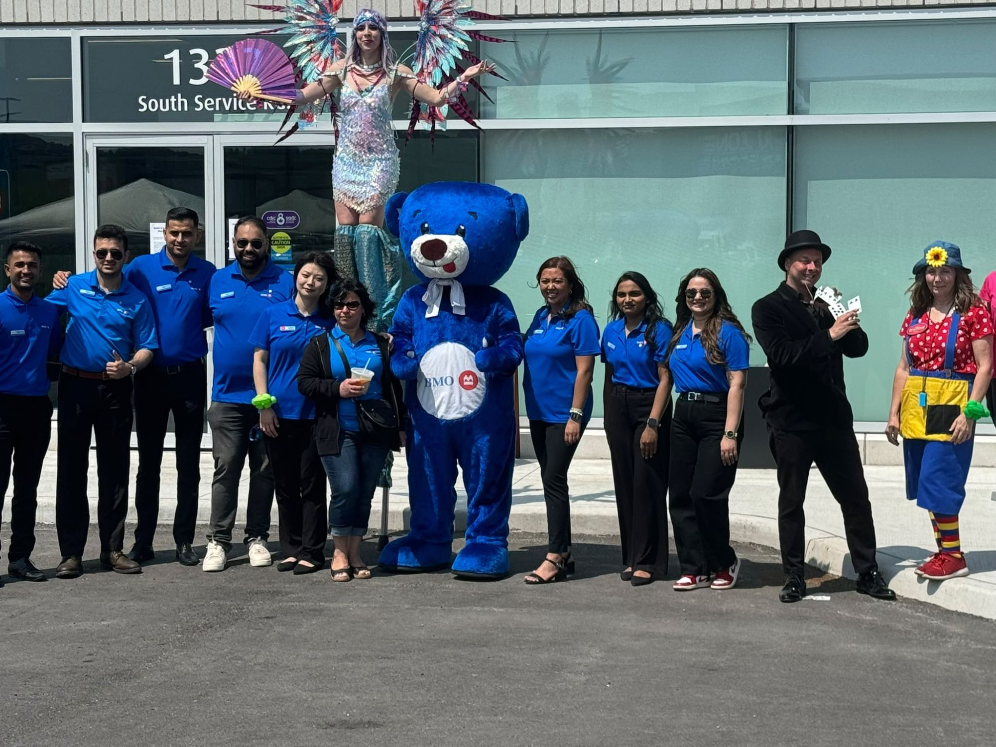 BMO branch team with the BMO bear mascot and performers at the branch grand opening