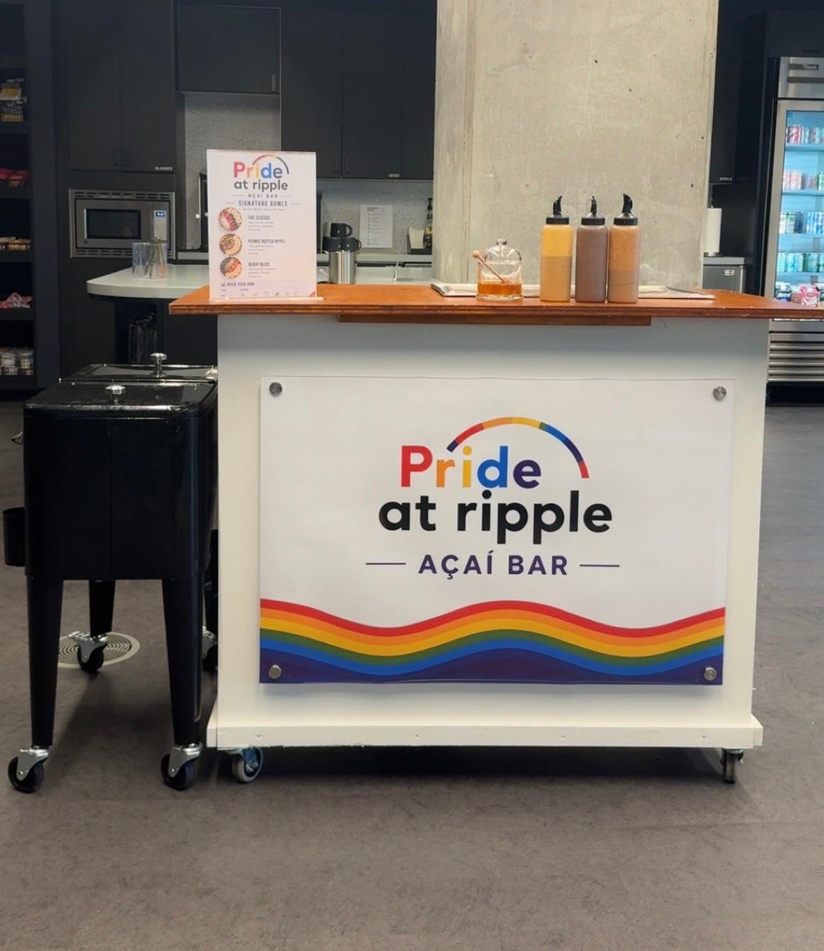 Pride at Ripple açaí bar cart with a rainbow-branded panel and toppings
